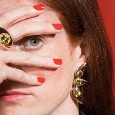 Photo of the jewellery designer Cora Sheibani, wearing rings and earrings from her collection