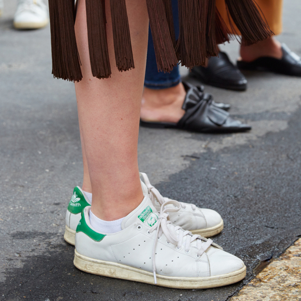 Woman wearing classic Stan Smith sneakers with skirt.