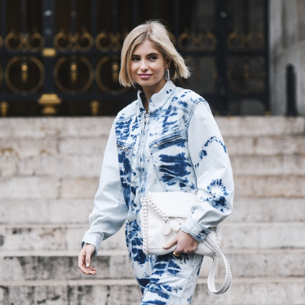 A fashion show goer wearing a double denim look.