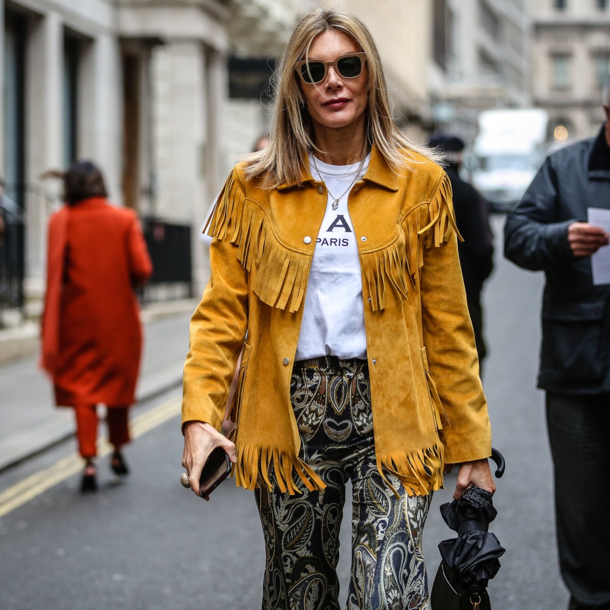 fashionista in the streets of Milan during fashion week wearing a leather fringe jacket