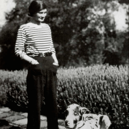 Coco Chanel in a garden with a dog.