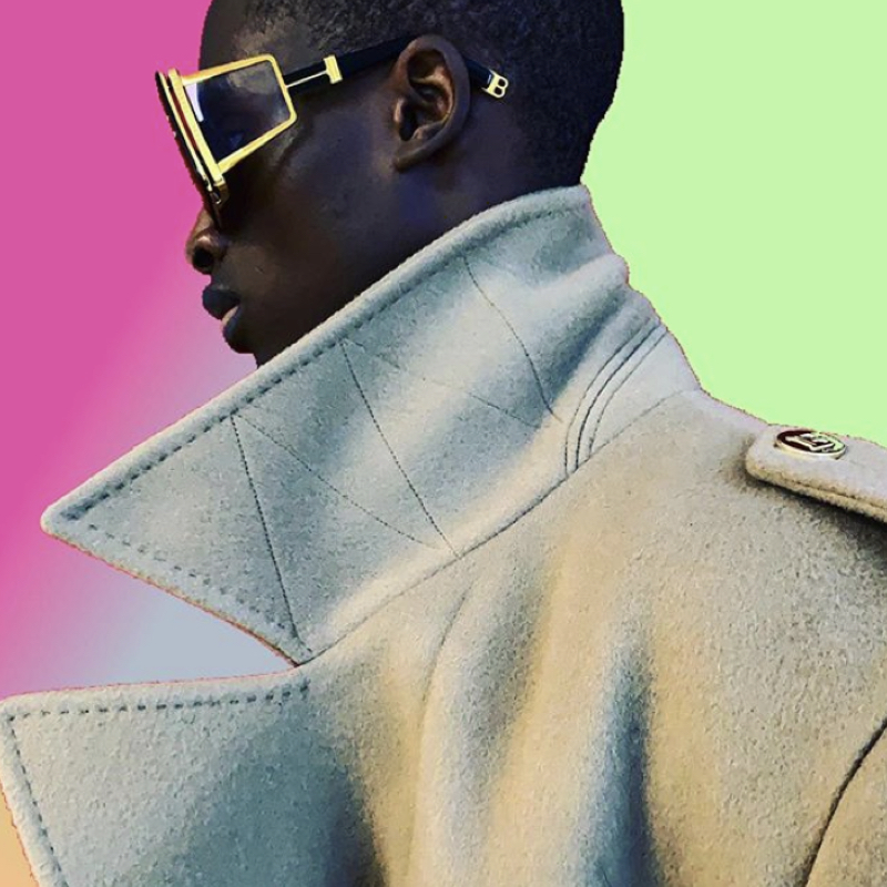 Model on TikTok wearing Balmain sunglasses and white coat.