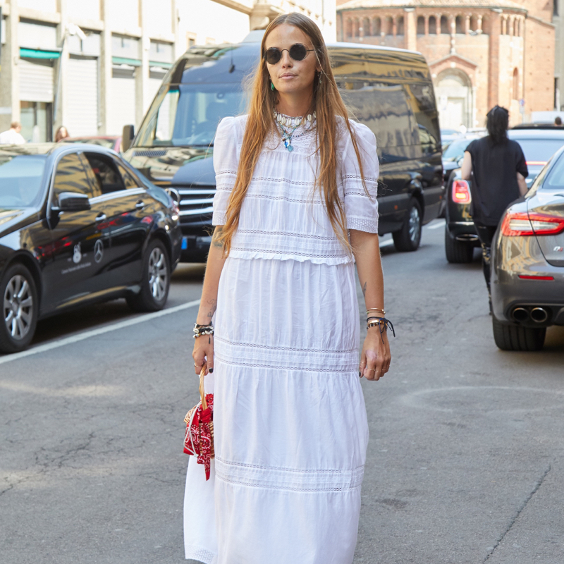 Stylish woman wearing a white dress during Fashion Week.