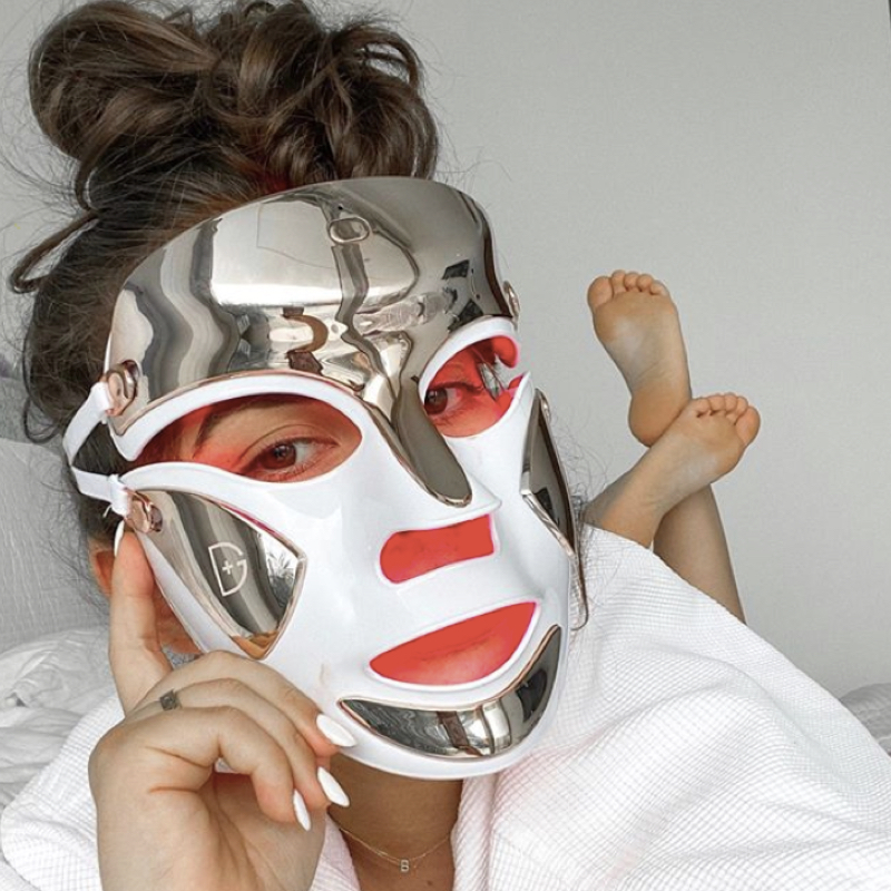 Woman relaxing with a LED light mask on her face.