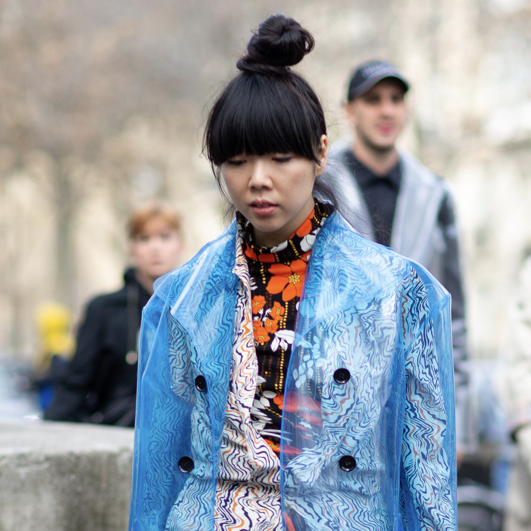 Woman wearing a raincoat, one of the items you need in April for a perfect spring outdoor wardrobe.