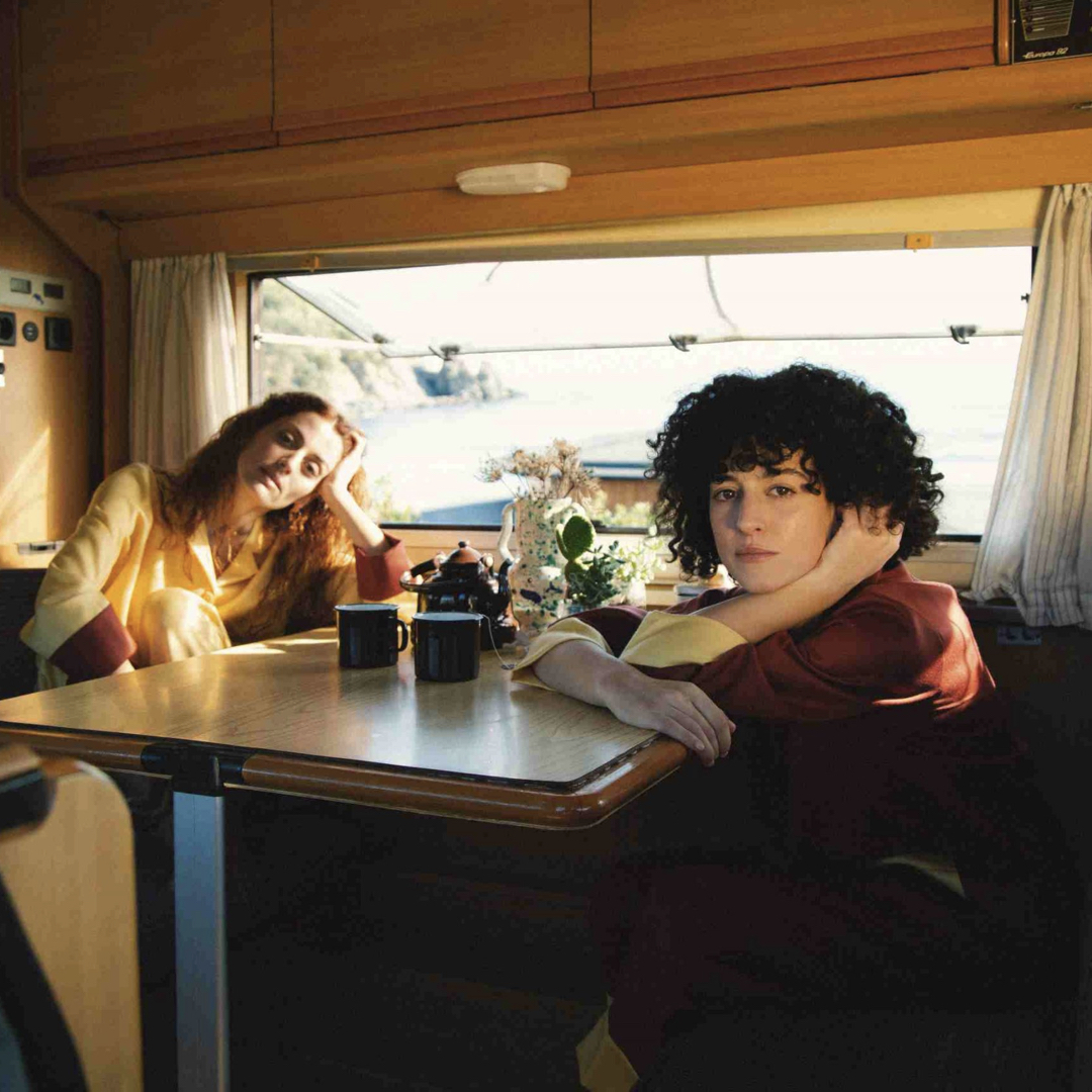 two models in a trailer car somewhere in Spain wearing La Veste clothes