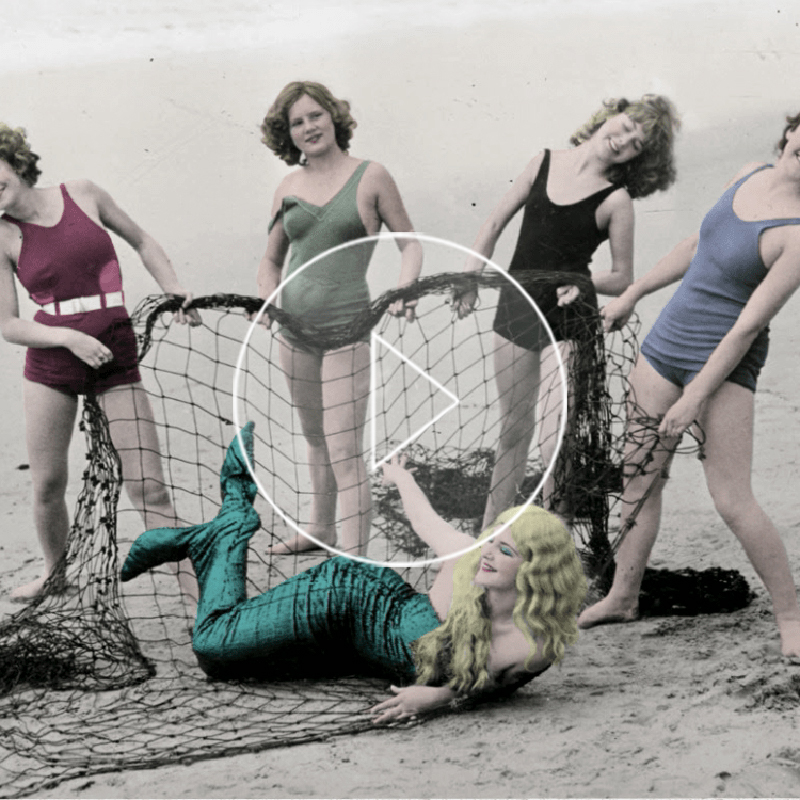 vintage image of a mermaid being rescued by fisherman on a beach