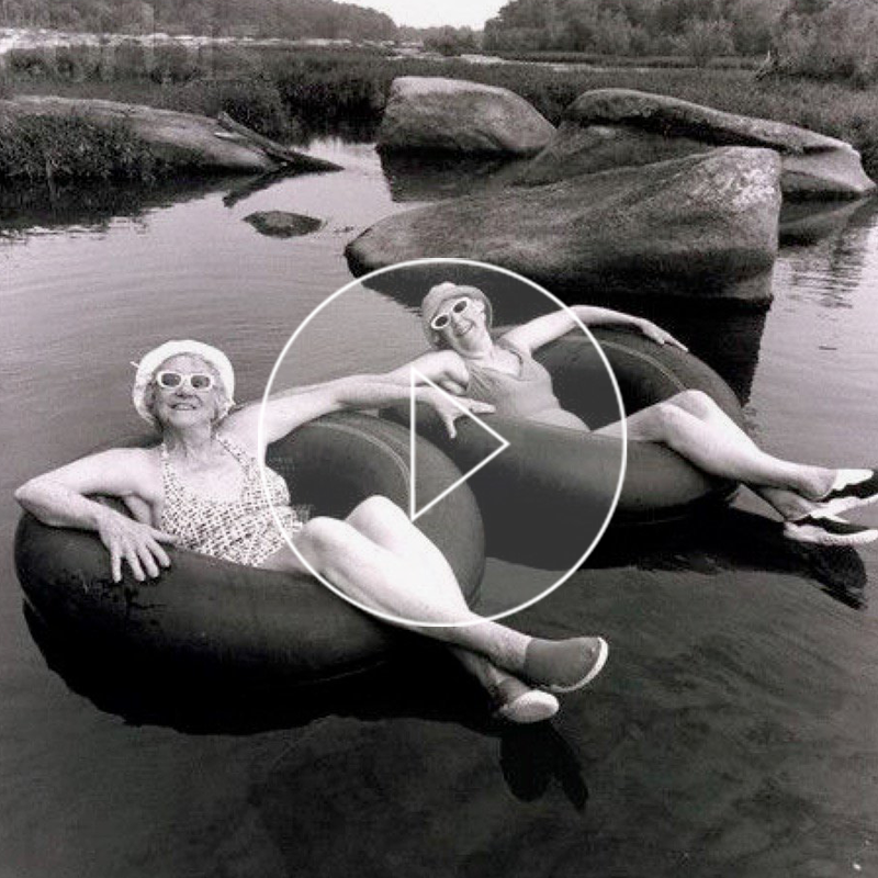 Two happy older women floating on a river.