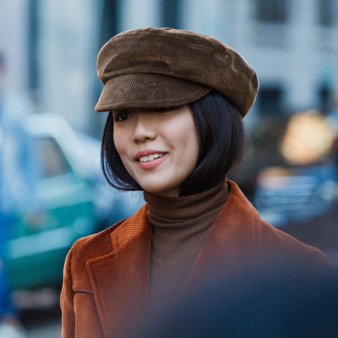 fashionista wearing a jacket and a hat in brown corduroy during fashion week