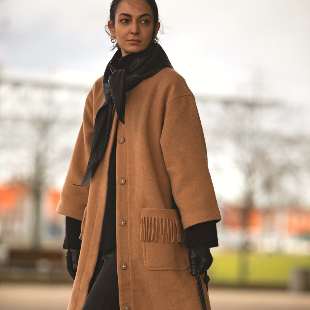 fashionista wearing a camel coloured coat in the streets of Copenhagen during the fashion week