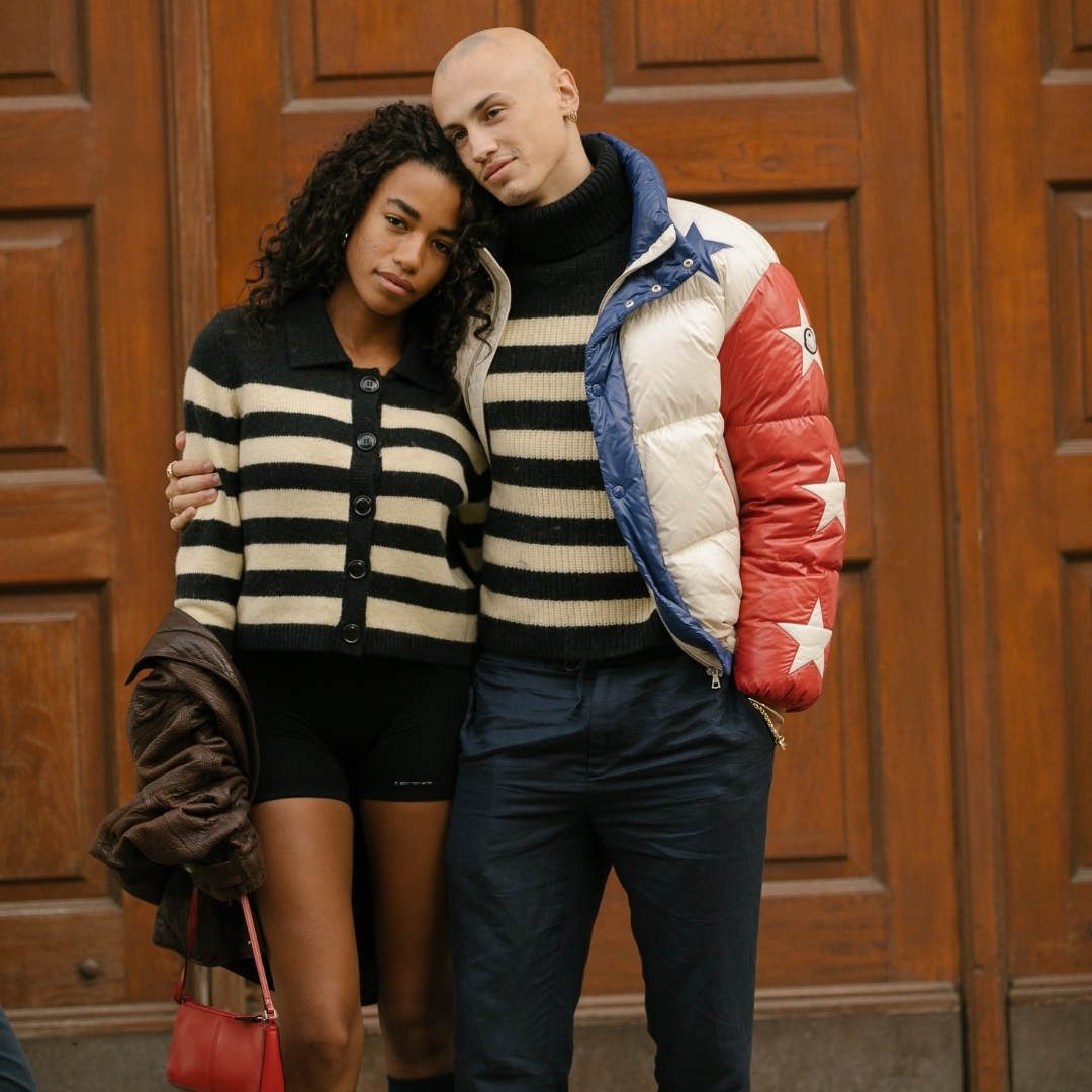 Fashionista couple posing to the cameras, in the streets of Copenhagen, is wearing the same striped pullover.