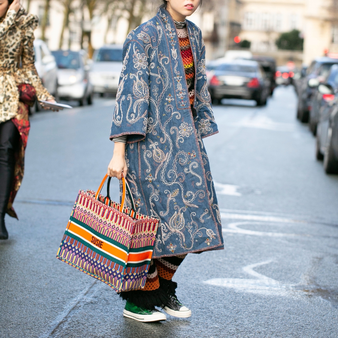 fashionista in paris fashion week, wearing a big dior tote bag