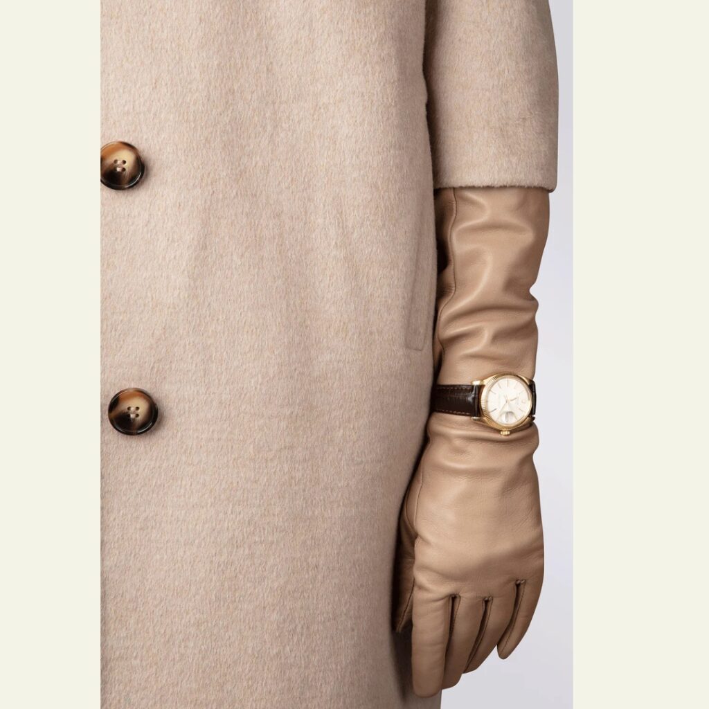 detail_of_a_woman_wearing_a_long_beige_leather_glove_and_a_wristwatch_over_it_Handsome_Stockholm