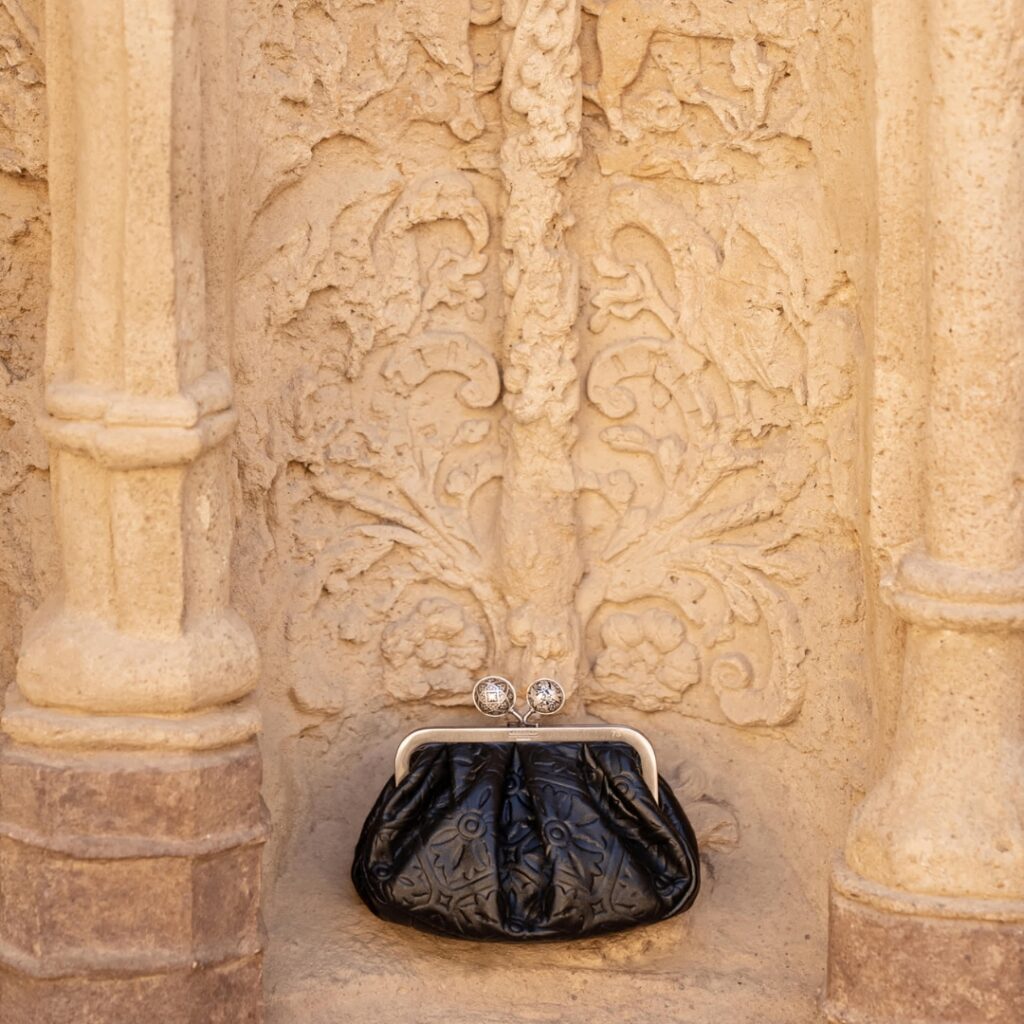 Weekend Max Mara bag photographed against a wall of an ancient building in Granada, Spain