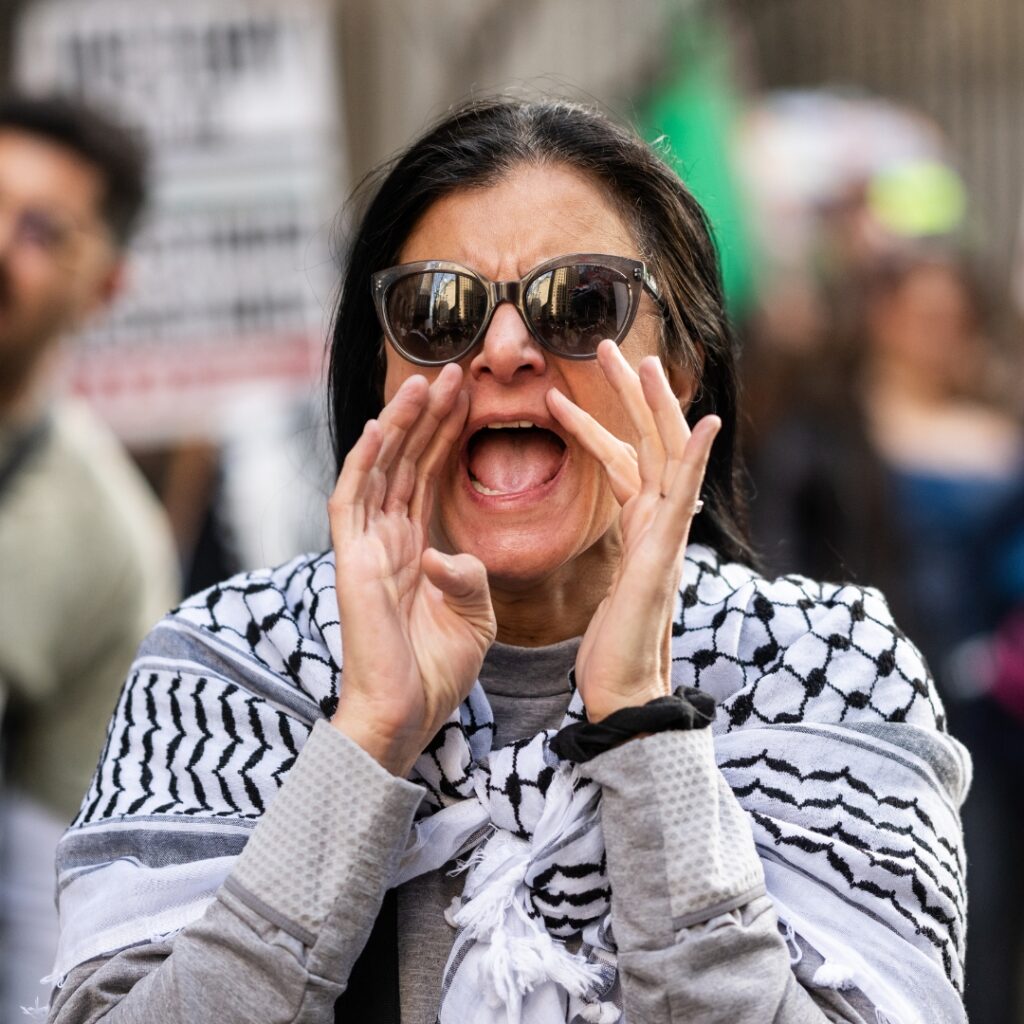 protester demonstrating in front of Israeli Embassy wearing a palestinian scarf