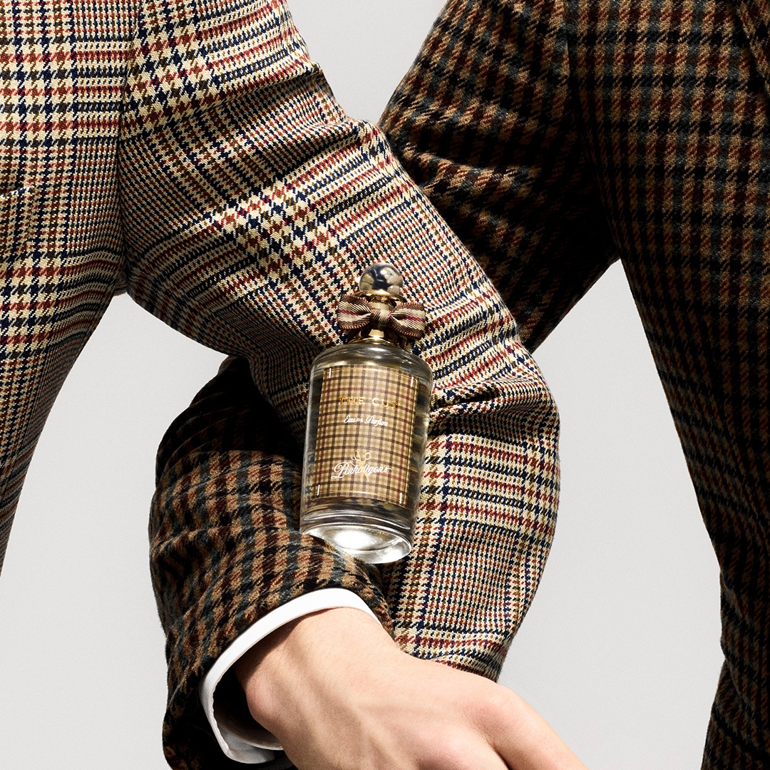 Two masculine arms intertwined, dressed in Savile Row tweed, and between them, the new fragrance The Cut by Penhaligons