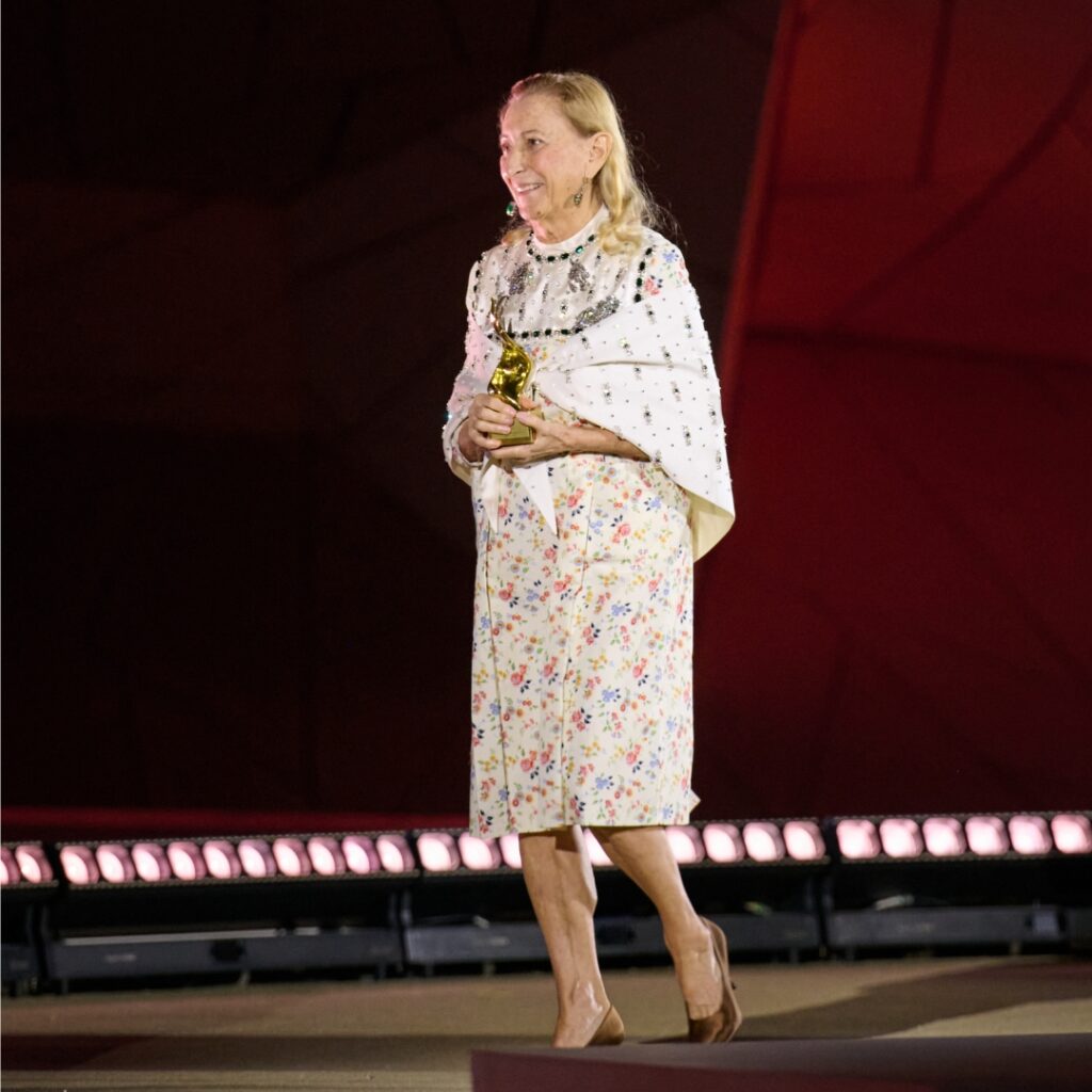 Miuccia Prada, founder of Prada and Miu Miu, photographed in a white embroidered dress and cape, in Doha by FTA