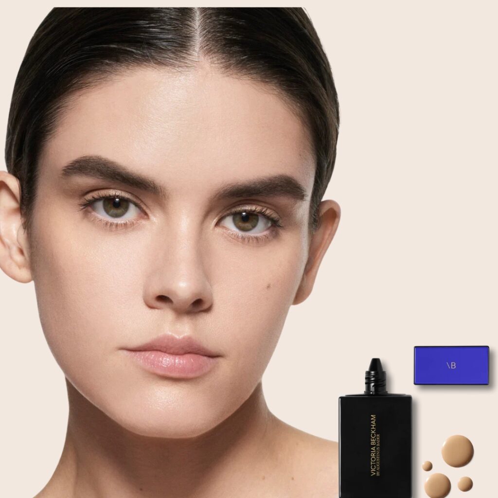 Model wearing Victoria Beckham Foundation Drops with sleek packaging and serum texture.