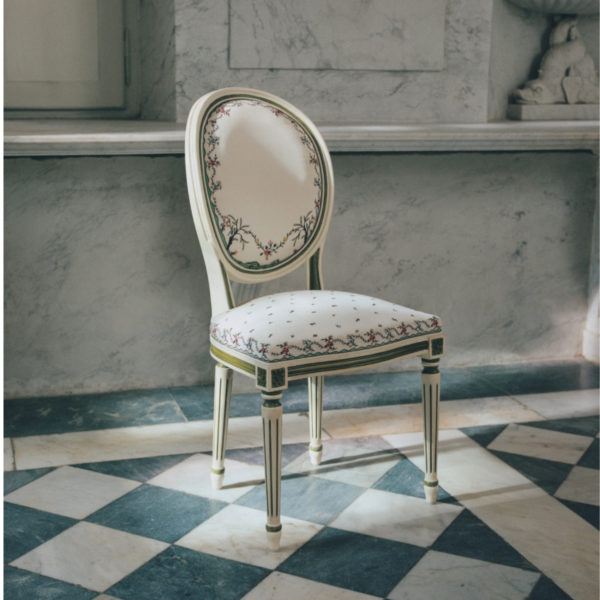 Dior medallion Chair with embroidered flowers fabric stands on a marble floor