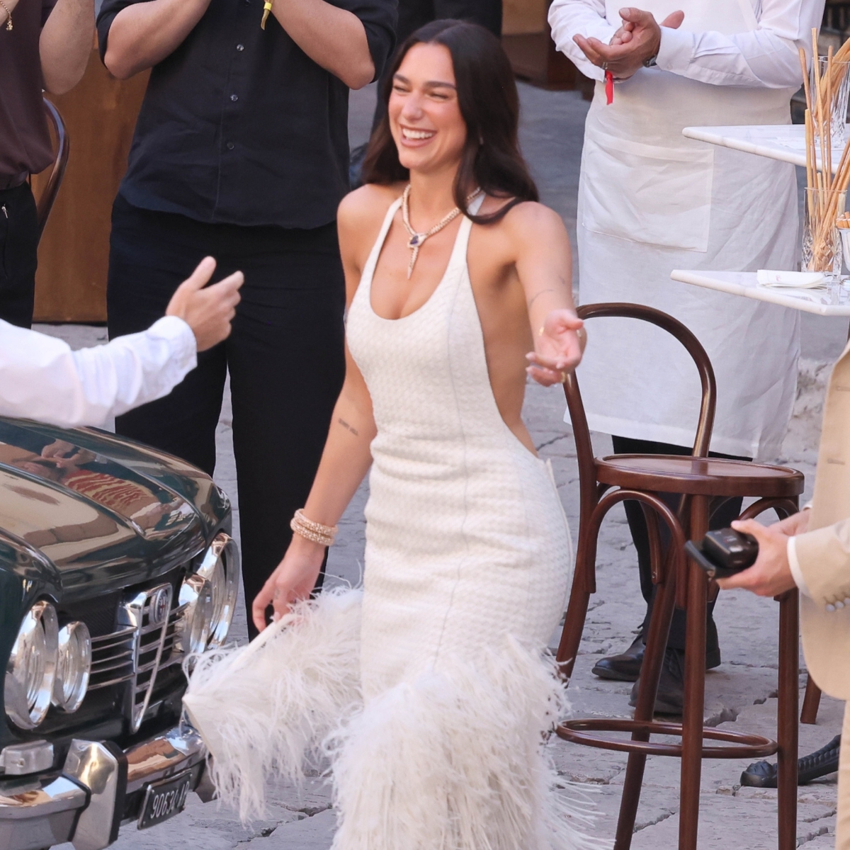 dua lipa wearing a white Bottega Veneta dress greets some guests in her wedding in Palermo